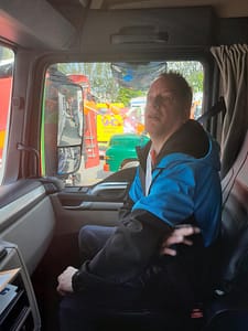 Mark een jongen met een beperking in zijn blauw jas in de vrachtwagen bij BUKOM.